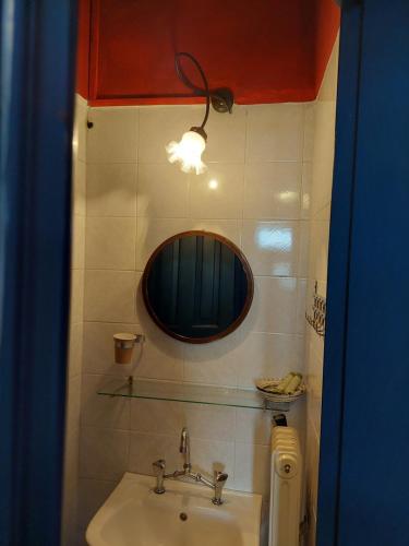 a bathroom with a sink and a mirror at House Mitsiou Traditional Inn in Arnaia