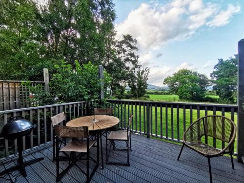 um pátio com uma mesa e cadeiras num deque em Moneylands Farm Self-Catering Apartments em Arklow