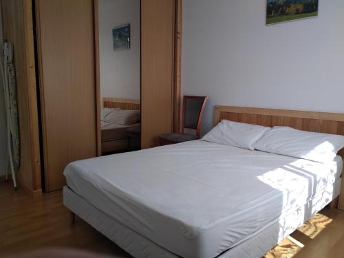 une chambre avec un lit blanc et une chaise dans l'établissement Maison 5 personnes à Noirmoutier, à Noirmoutier-en-l'lle