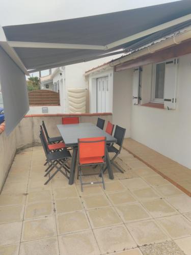 un patio avec une table et des chaises sur un balcon dans l'établissement Maison 5 personnes à Noirmoutier, à Noirmoutier-en-l'lle