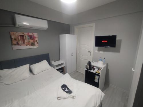 ein Schlafzimmer mit einem Bett mit einem Paar Schuhe darauf in der Unterkunft THE LİMA SUİTES KADIKÖY in Istanbul