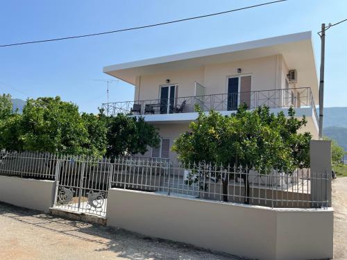 a house with a fence in front of it at Koulouras Holiday Apartments in Nikolaíika