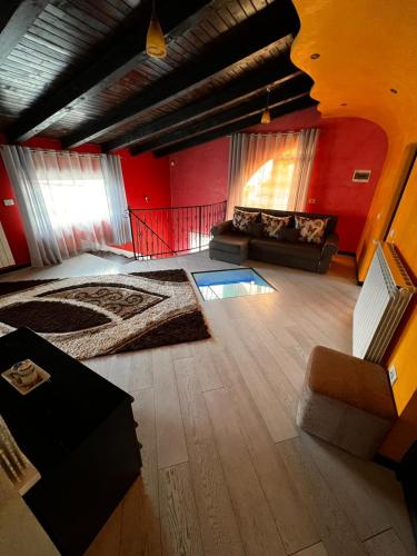 a large living room with red walls and a couch at Vila Bijou in Borşa