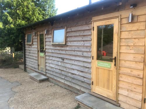 a wooden cabin with a door and a window at Scallow Campsite in Lewes