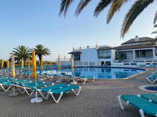 a swimming pool with lounge chairs and a resort at Beach House Golden Club in Cabanas de Tavira
