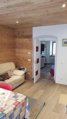 a living room with wooden walls and a room with a bed at Casa Gion in Santo Stefano di Cadore