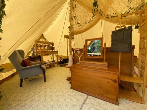 a room with a tent with a chair and a dresser at Hope Cottage Bell Tent Retreat in Ashbourne