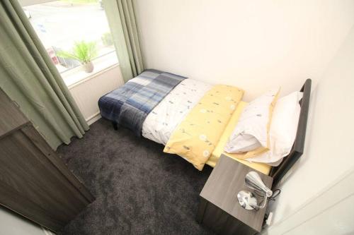 a small bedroom with a bed and a window at Exceptional 3 Bed, Great Location in Ashby Ideal for Travellers, Short Holiday Stays And Contractors in Brumby