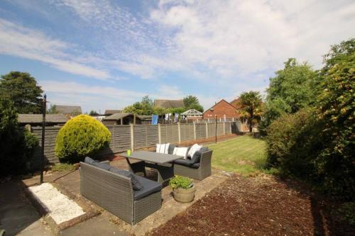 a patio with a table and chairs in a yard at Exceptional 3 Bed, Great Location in Ashby Ideal for Travellers, Short Holiday Stays And Contractors in Brumby