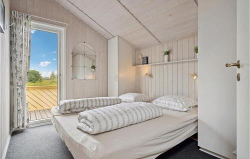 SpodsbjergにあるBeautiful Home In Rudkbing With Sauna, Private Swimming Pool And Indoor Swimming Poolのベッド4台、大きな窓が備わる客室です。