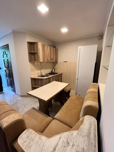 a living room with a table and a kitchen at Green Park Guest House in Dilijan