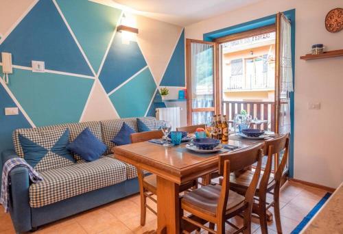 a dining room with a table and a couch at Happy Guest Apartments - Alpin Vista Colere in Colere