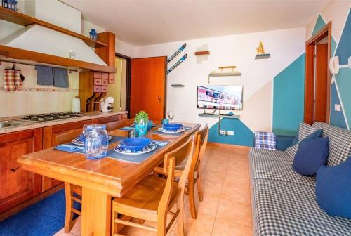 cocina y comedor con mesa de madera y sillas en Happy Guest Apartments - Alpin Vista Colere en Colere