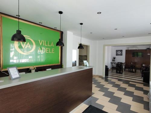 a lobby with a large green sign on the wall at VilLa AdeLe in Siófok