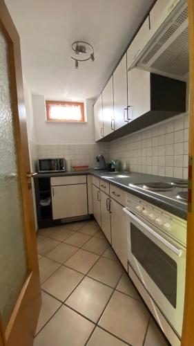 a kitchen with white cabinets and a stove top oven at Apartment Bärenfelsblick in Wehr