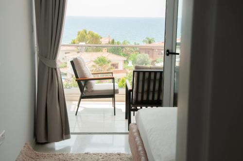 a bedroom with a view of the ocean from a balcony at Seaview apartments in Ayios Elias