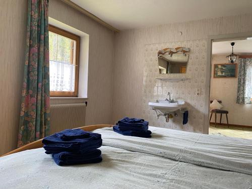 um quarto com uma cama com lençóis azuis e um lavatório em Haus Tanne Abtenau em Abtenau