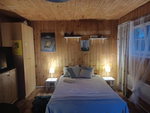 1 dormitorio con 1 cama y 2 mesas con lámparas en Margarita's cottage, en Jūrmala