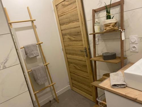 - une salle de bains avec une porte en bois à côté d'un lavabo dans l'établissement Villa Sofia, à Malemort-du-Comtat