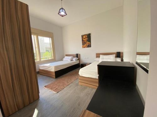 1 dormitorio con 2 camas y ventana en Hacienda Bay Luxury Chalet هاسيندا باي, en El Alamein