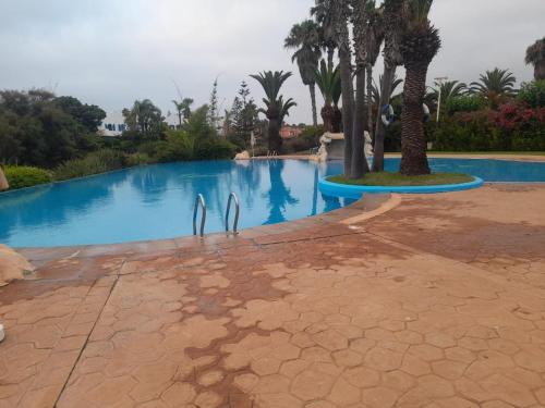 a swimming pool with two dolphins in the water at Villa à Bouznika Bay-plage et golf in Bouznika