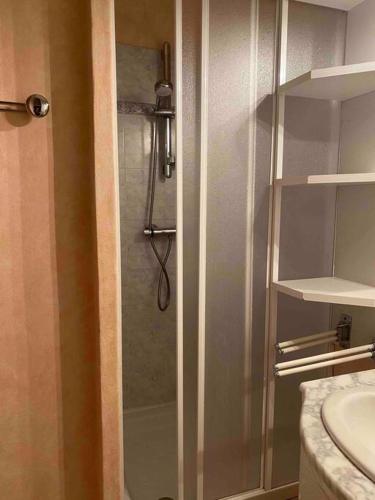 une douche avec une porte vitrée dans une salle de bain dans l'établissement Studio 30m2 pour 4 pers La Mongie avec canape-lit et lit superposé, à La Mongie
