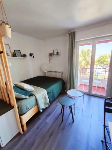 une chambre avec un lit et un balcon dans l'établissement Appart cocooning proche centre avec Parking, climatisation, à Hyères