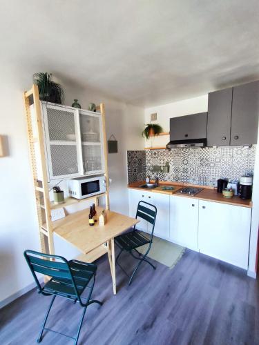 - une cuisine avec une table et des chaises en bois dans la chambre dans l'établissement Appart cocooning proche centre avec Parking, climatisation, à Hyères