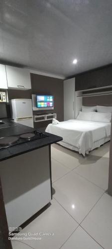 1 dormitorio con 1 cama y TV en Dlanduna GUEST House en Umzinto