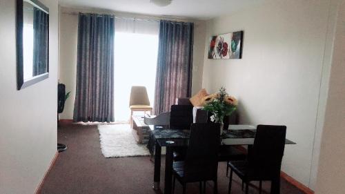 a dining room with a table and chairs and a window at Menlyn Bizcation Accommodation in Pretoria