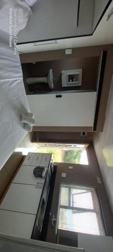 uma vista para uma cozinha com um lavatório e uma janela em Dlanduna GUEST House em Umzinto