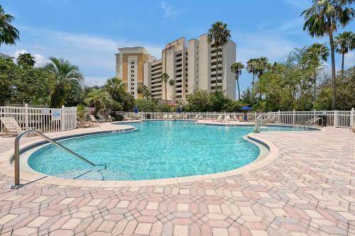 a swimming pool in a resort with buildings in the background at Cozy Condo on International Dr. Near Universal Studios in Orlando