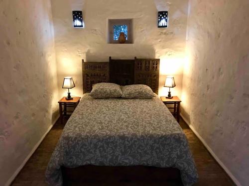 a bedroom with a bed with two lamps on two tables at Villa Oleya Belle demeure nature in Essaouira