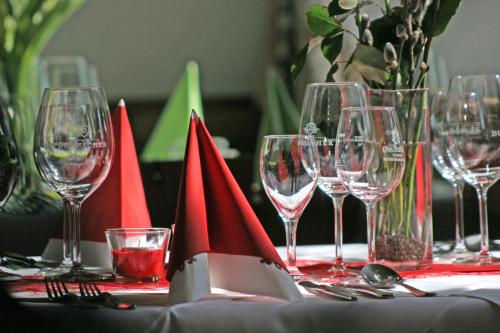 Landgasthof Rößle في Berau: طاولة مليئة بأكواب النبيذ والمناديل الحمراء