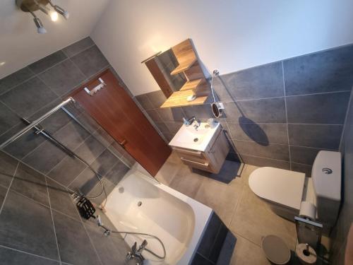 a bathroom with a tub and a sink and a toilet at Miu's Ferienwohnung in Alpirsbach