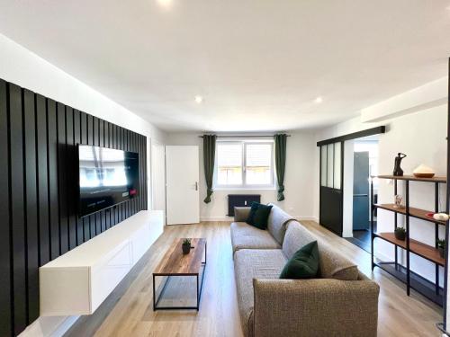 un salon avec un canapé et une télévision dans l'établissement Le petit cocon Alsacien, à Wasselonne