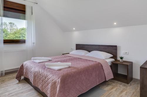 a bedroom with a large bed with two white pillows at Deluxe Apartment with Jacuzzi - PATAR in Rakovica