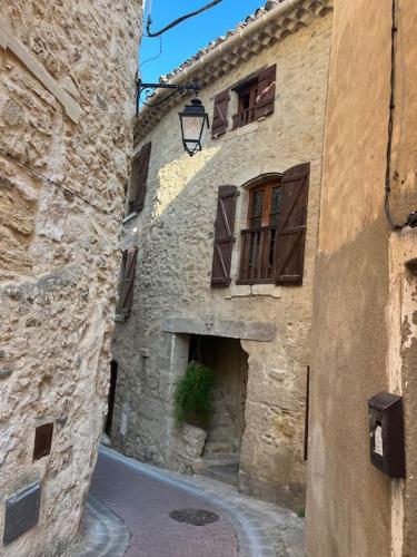 une allée dans un ancien bâtiment en pierre avec une fenêtre dans l'établissement Charming village house with roof top terrace!, à Thèzan-lès-Béziers
