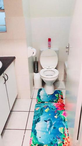 a bathroom with a toilet with a fish rug on the floor at Menlyn Bizcation Accommodation in Pretoria