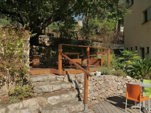 a patio with a stone wall and a table and chairs at Camping aux Vallons in Bauduen