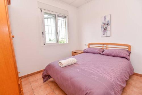 Un dormitorio con una cama con sábanas moradas y una ventana en Villa Rural Piscina fortuna luxury23 personas 10 Habitaciones habitaciones wifi, en Fortuna