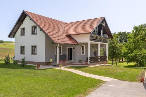 a white house with a red roof at Deluxe Apartment with Jacuzzi - PATAR in Rakovica