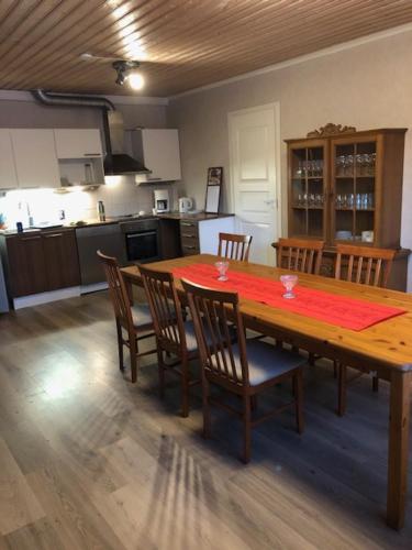 a kitchen with a wooden table with chairs and a tableablish at Viivin tuvat asunto A ja B in Alavus