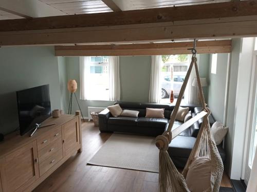 a living room with a couch and a hammock at Uniek vakantiehuis - nabij molen, meer, strand & stad' in Hoorn