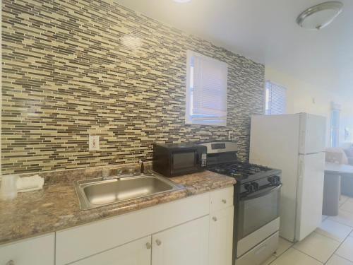 a kitchen with a sink and a microwave at Shore Beach Houses - 40 - 1 Dupont Ave in Seaside Heights