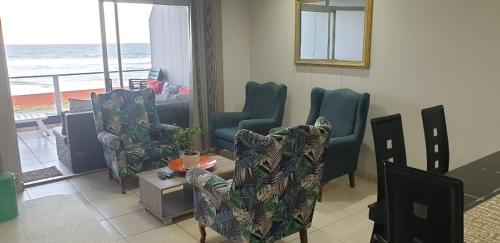 una sala de estar con sillas y vistas al océano. en Rietvlei at Margate Boulevard en Margate