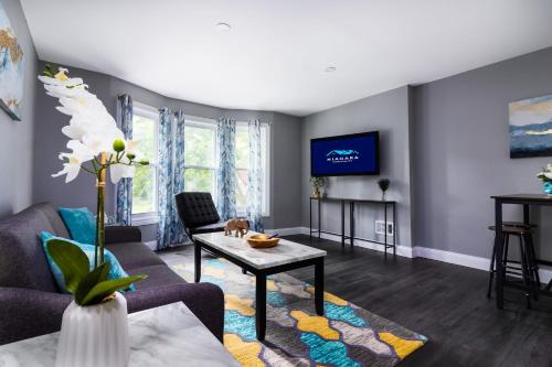 a living room with a couch and a table at Quaint 1 Bedroom Apartment Sleeps Near Niagara Falls & Casino in Niagara Falls