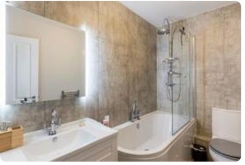 a bathroom with a tub and a sink and a shower at Liverpool Georgian Quarter 1 Bed Apartment Sleeps 4 in Liverpool