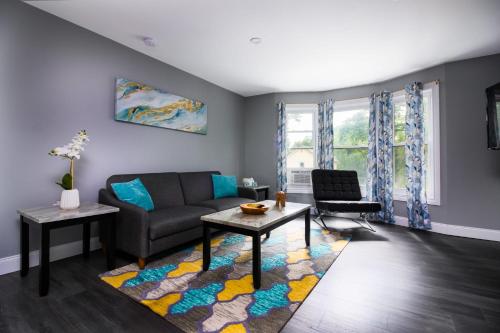 a living room with a couch and a table at Quaint 1 Bedroom Apartment Sleeps Near Niagara Falls & Casino in Niagara Falls