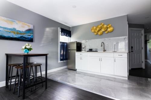 a kitchen with white cabinets and a table at Quaint 1 Bedroom Apartment Sleeps Near Niagara Falls & Casino in Niagara Falls